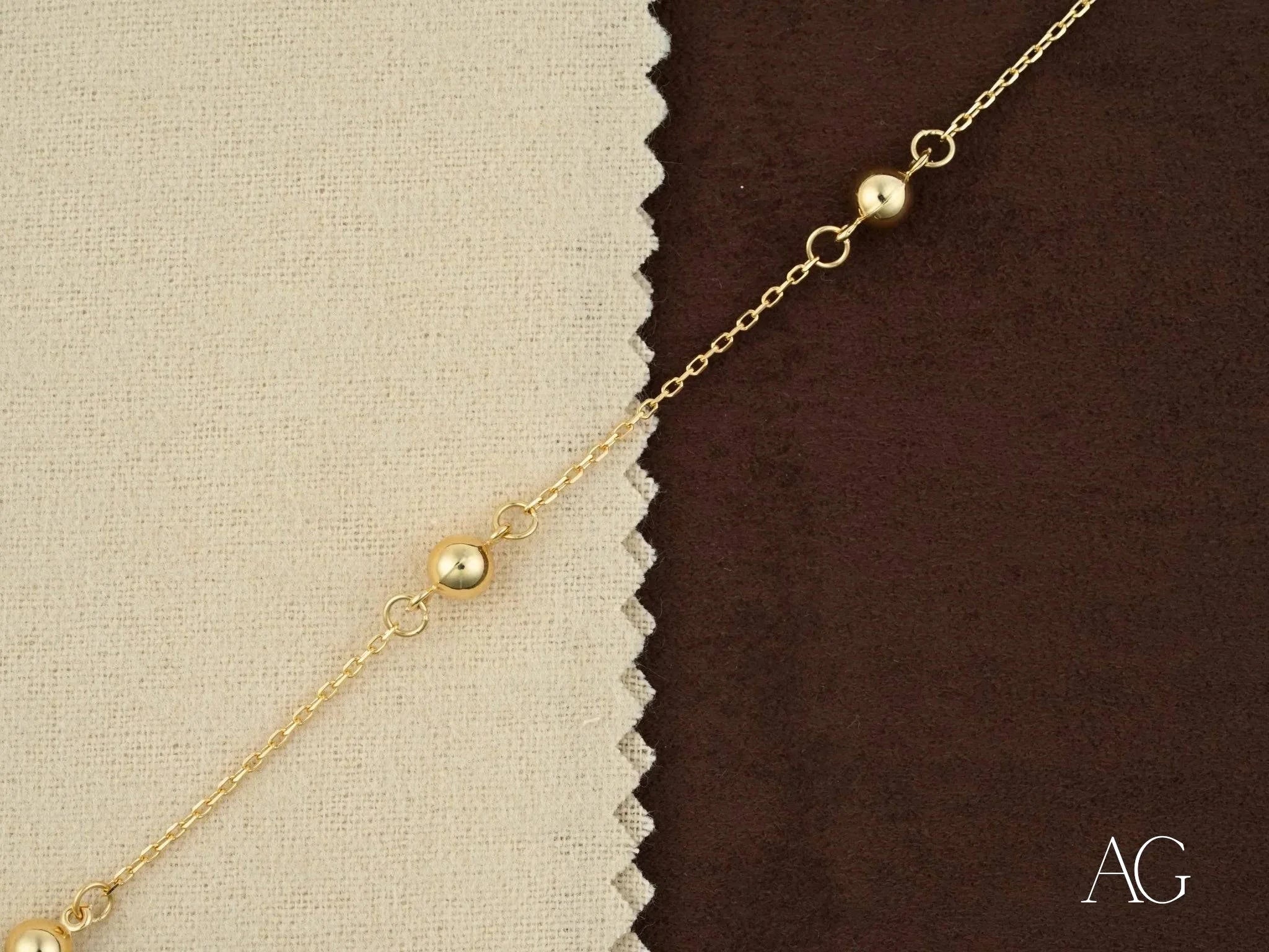 Delicate gold chain necklace featuring polished gold spheres in 18k gold design