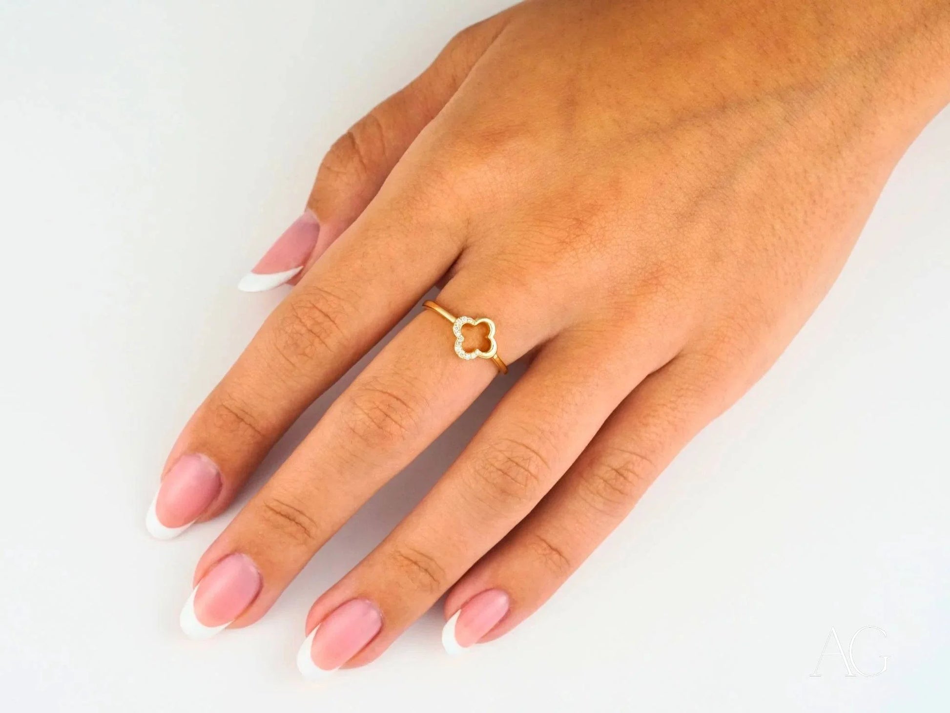 Delicate 18k flower diamond ring with hexagonal design worn on a finger