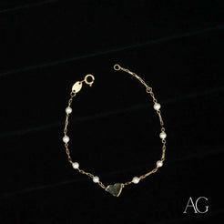 Elegant 18k gold heart bracelet with small pearls and a charming heart charm