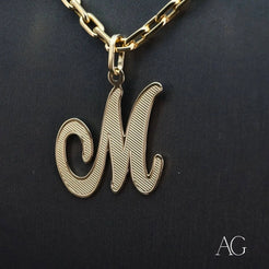 Elegant 18k Gold Letter M Pendant on a chain necklace, showcasing a cursive design