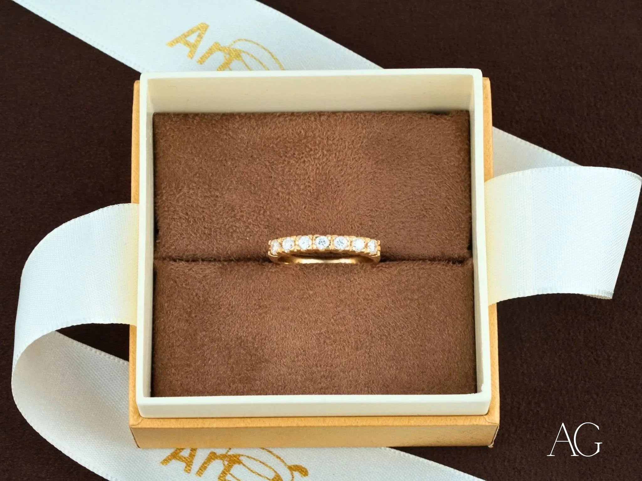 Gold ring with diamond accents in a jewelry box, showcasing 18k yellow gold elegance