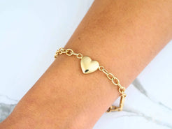 Elegant 18k gold bracelet with heart motifs worn on a wrist, embodying timeless style