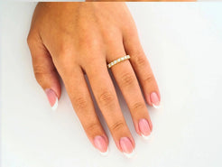 Hand showcasing an Elegant 18k yellow gold cz ring with pink nail polish