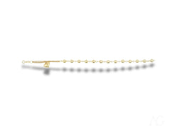 Elegant 18k gold bracelet with heart motif and polished gold beads, featuring pearl-like accents