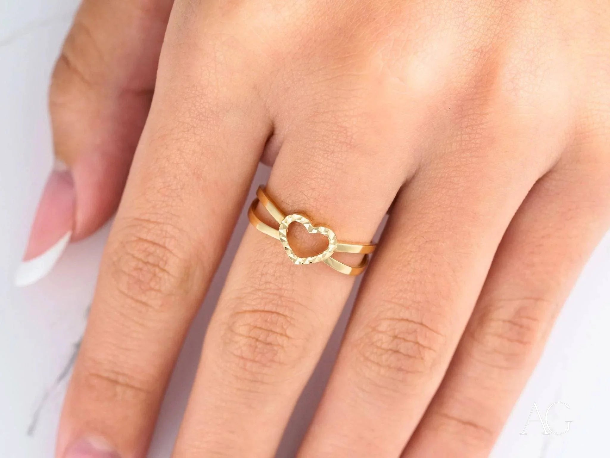 Elegant 18k yellow gold heart ring worn on a finger as a timeless love symbol