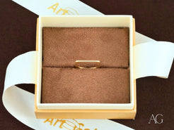 Elegant 18k yellow gold ring in a square jewelry box with beige velvet interior