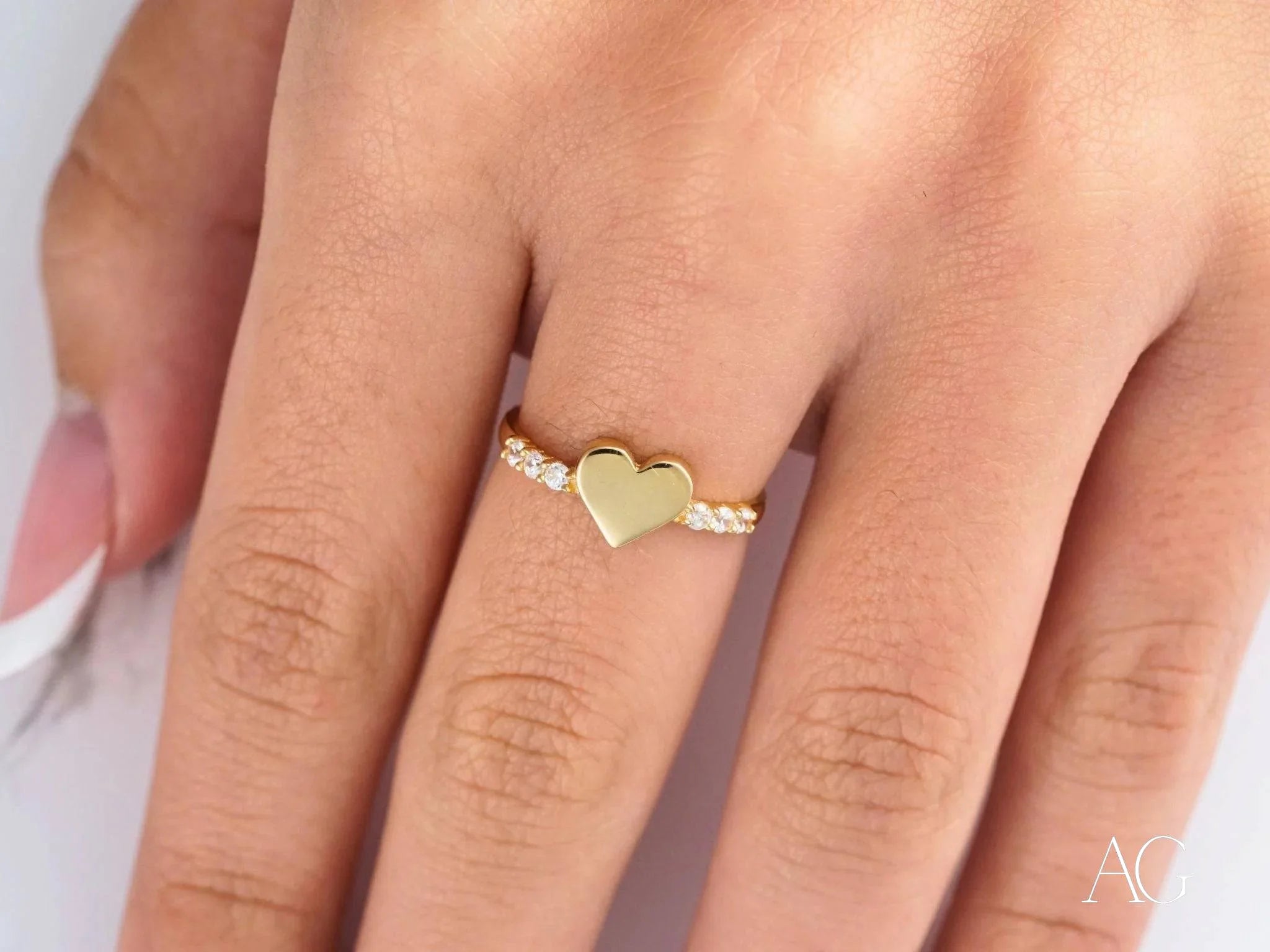 Gold heart-shaped ring in 18k yellow gold elegantly worn on a finger to celebrate love