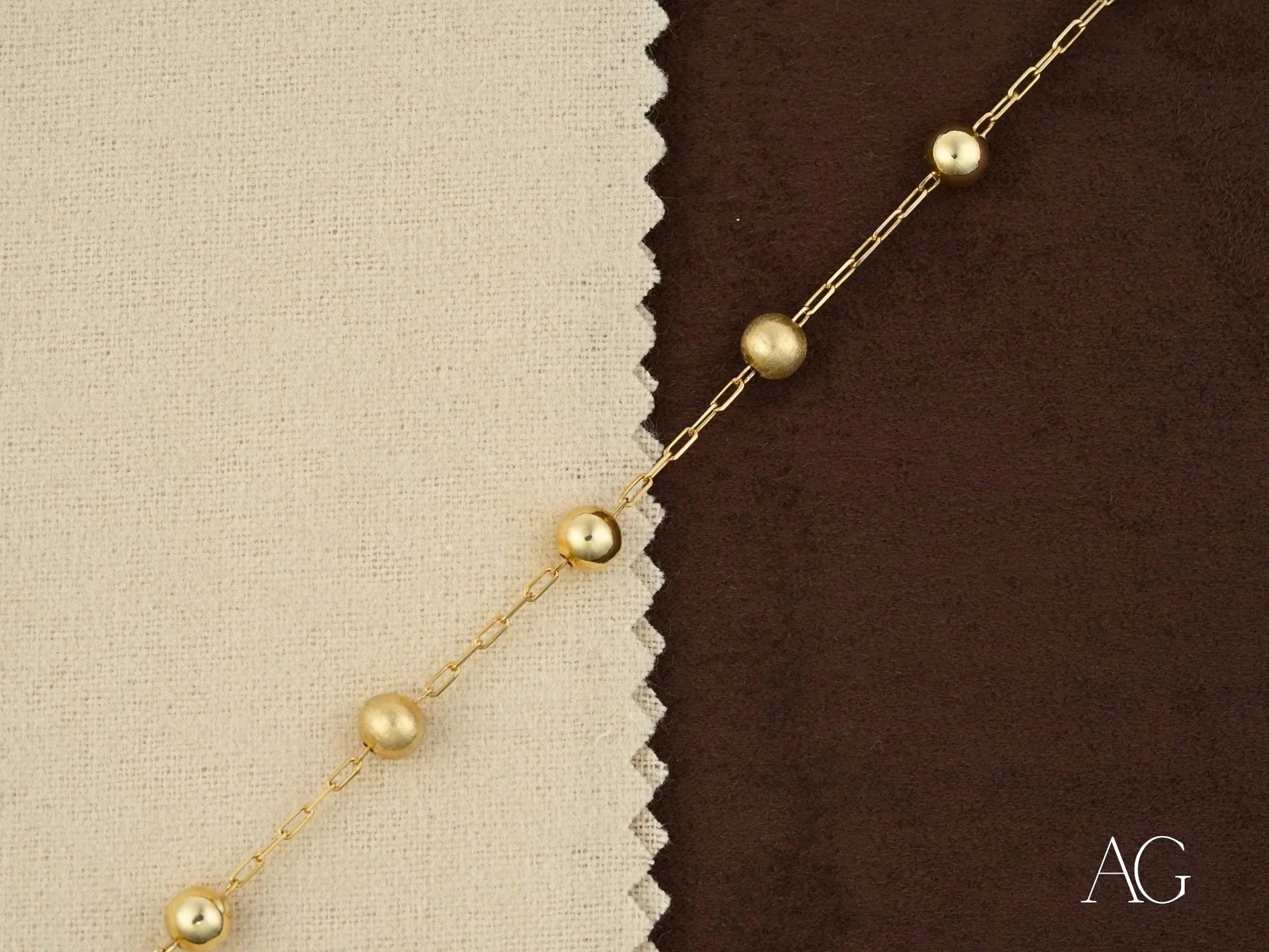 Delicate gold necklace with pearl-like beads featuring a spring ring clasp design