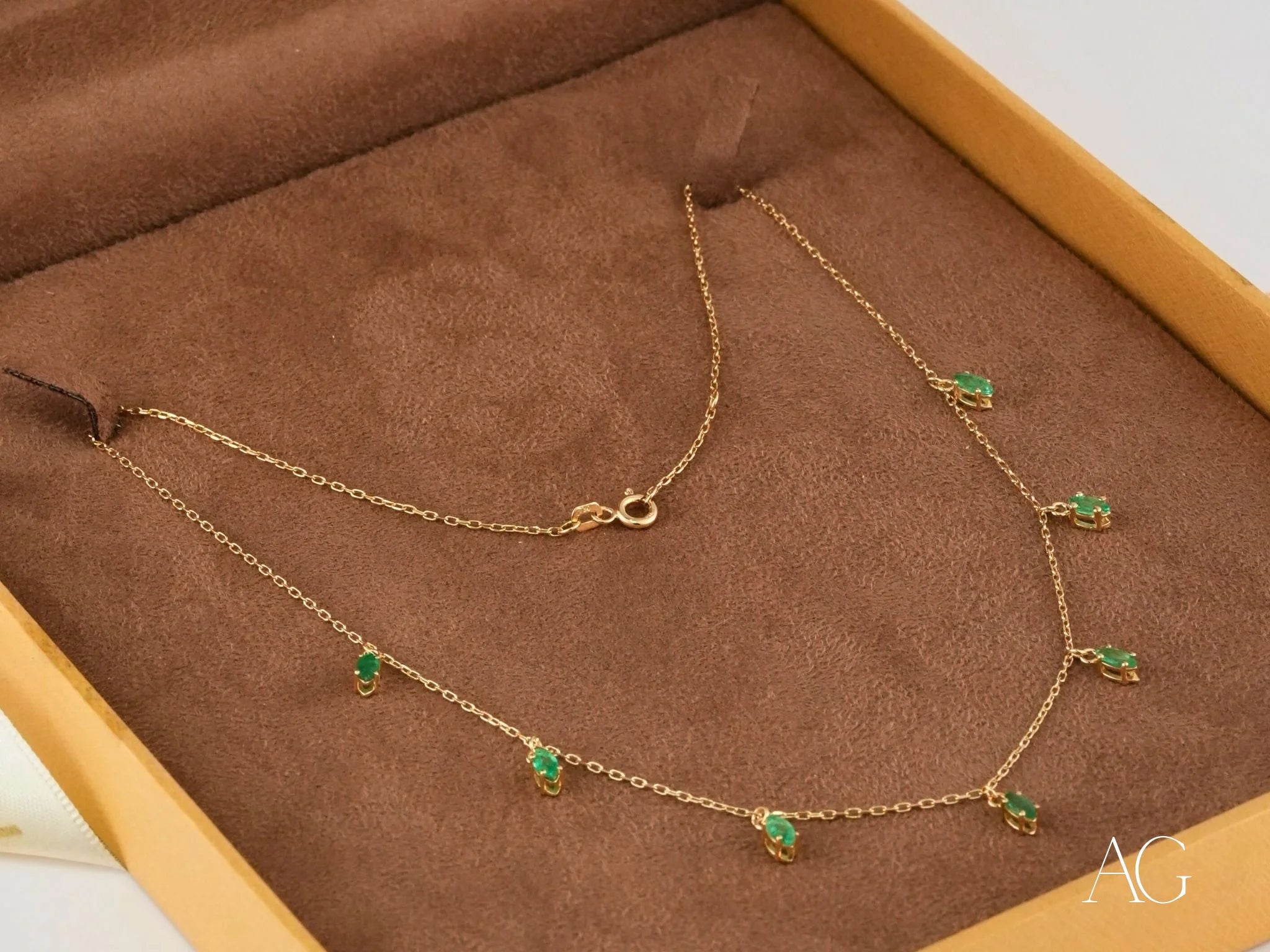 Gold necklace featuring marquise-cut emeralds in elegant emerald droplets design