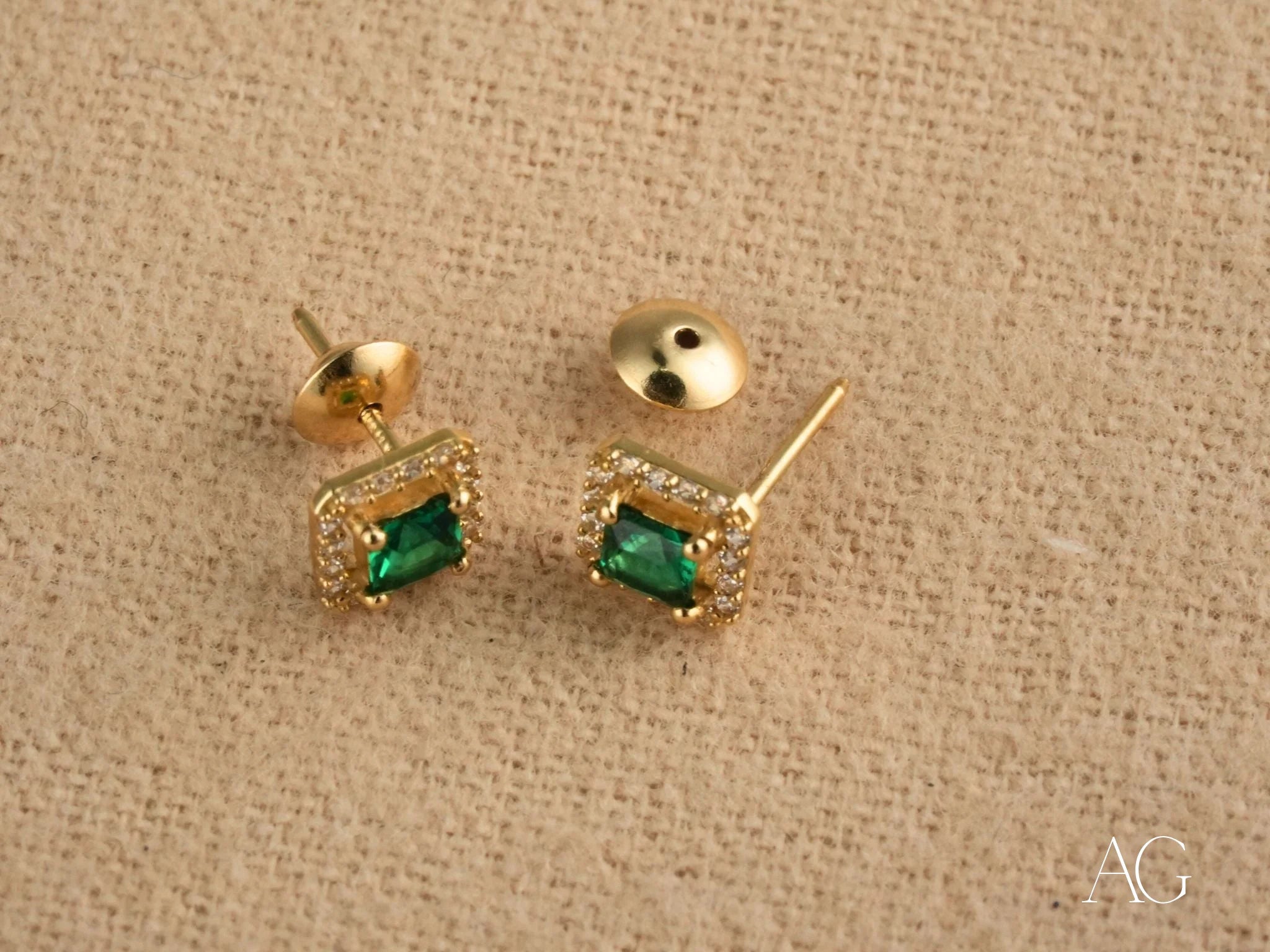 Gold halo stud earrings featuring green cubic zirconia for an emerald aura look