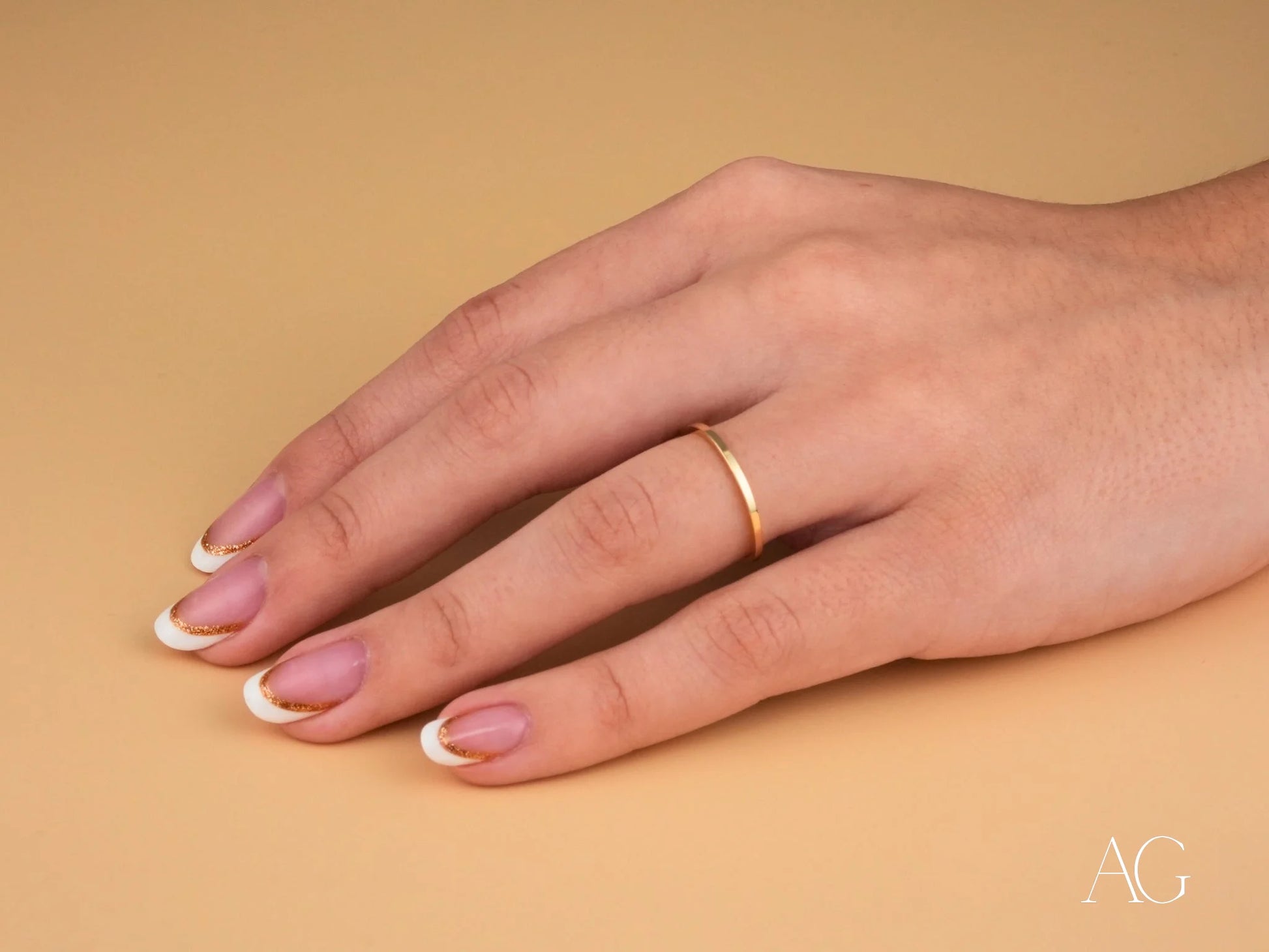 Minimalistic 18k gold ring from Essence Collection on manicured hand