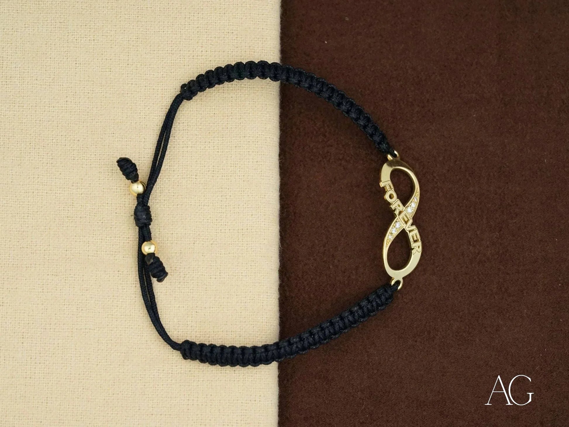 Black braided nylon band bracelet with 18k gold infinity charm for eternal elegance