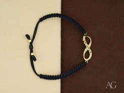 Black braided nylon band bracelet with 18k gold infinity charm for eternal elegance