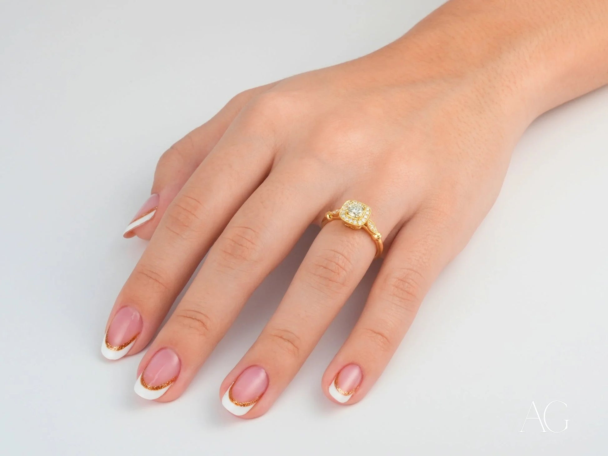 Yellow diamond center stone in 18k yellow gold ring on hand with French manicured nails