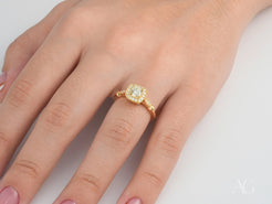 Gold engagement ring featuring a center diamond and halo in 18K yellow gold setting