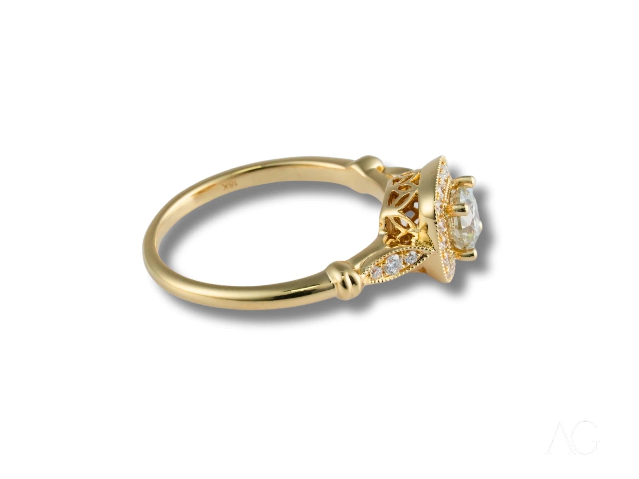 Gold engagement ring featuring a center diamond in 18k yellow gold with intricate detailing