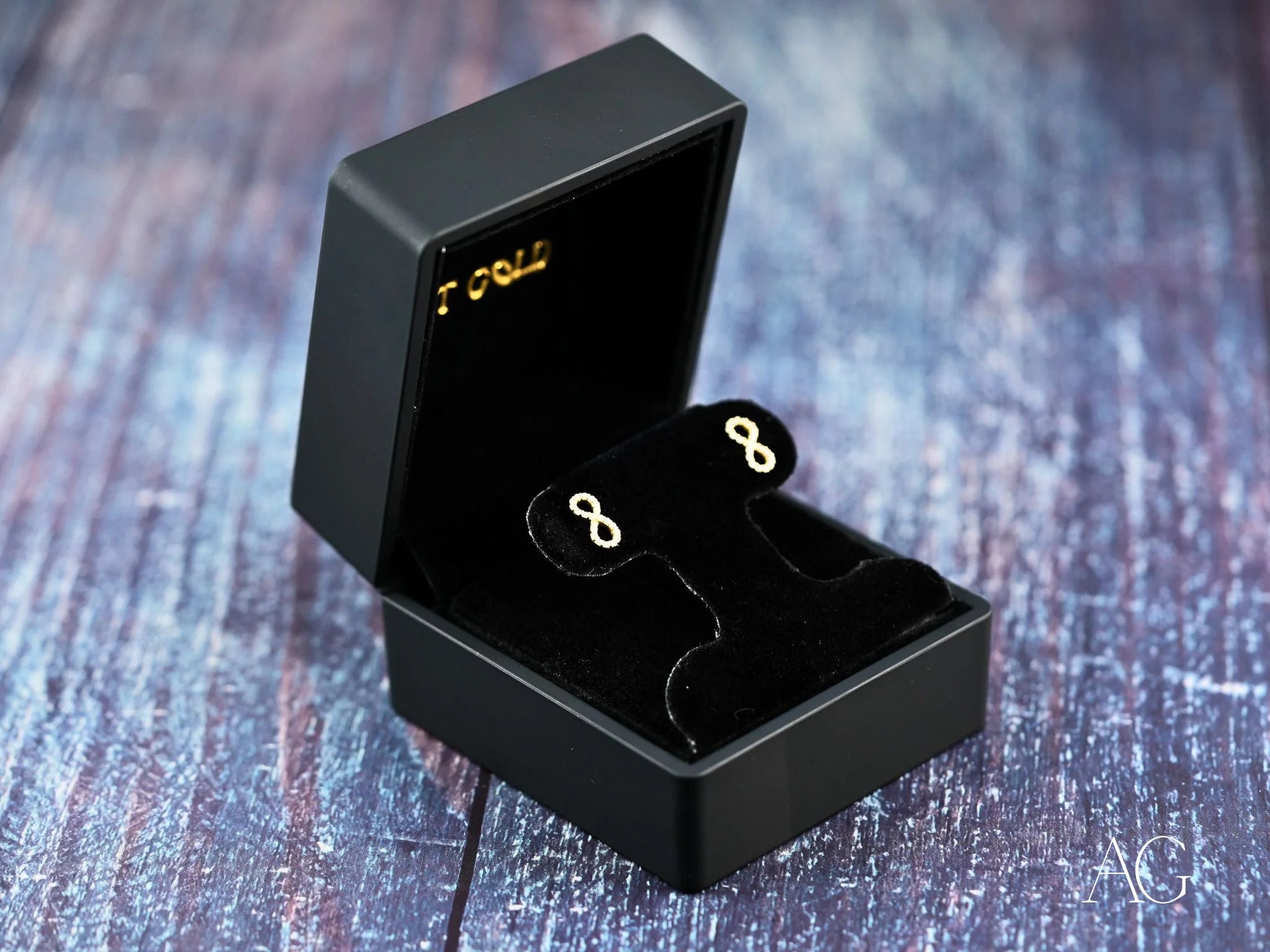 Black jewelry box displaying Eternal Spark 18K Gold Infinity CZ Earrings