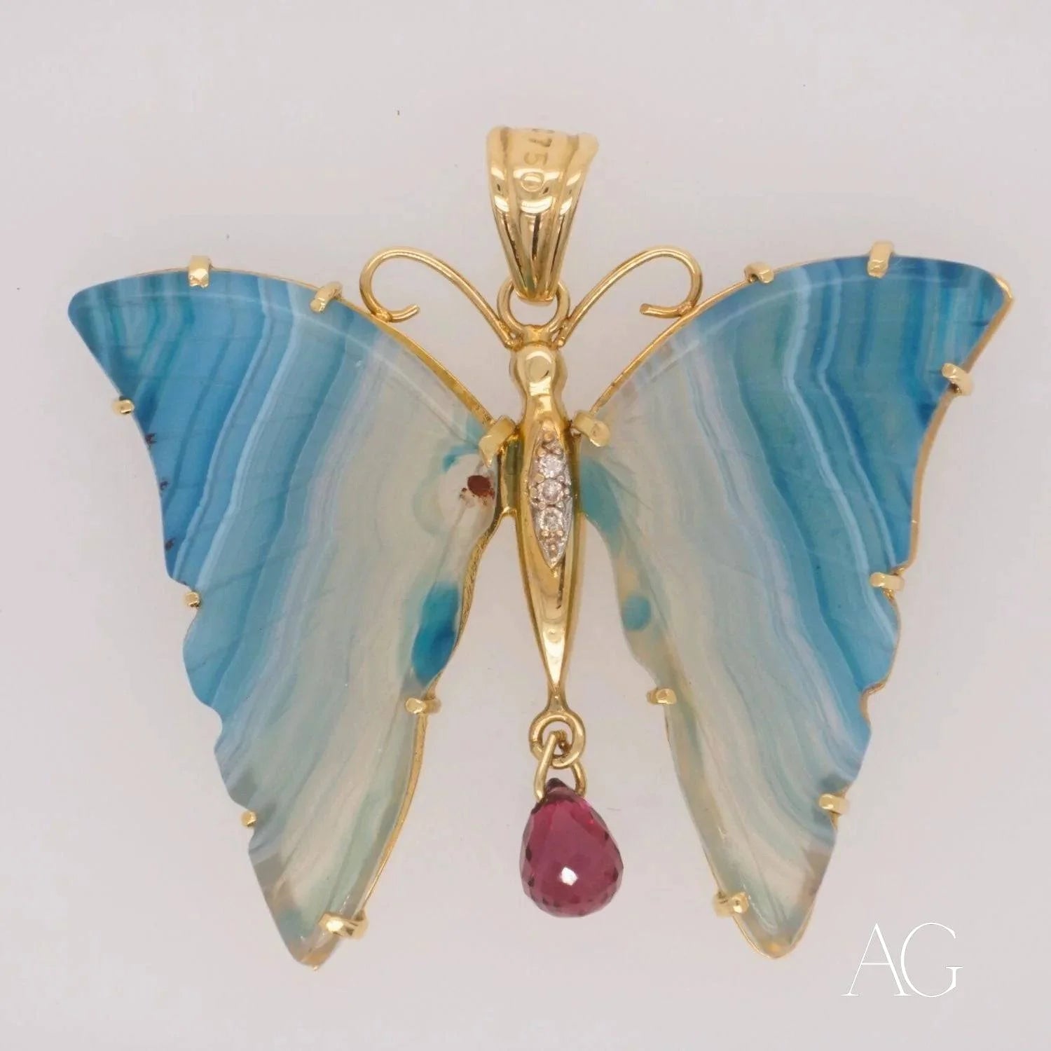 Butterfly pendant in 18k yellow gold with blue agate wings and ruby drop detail