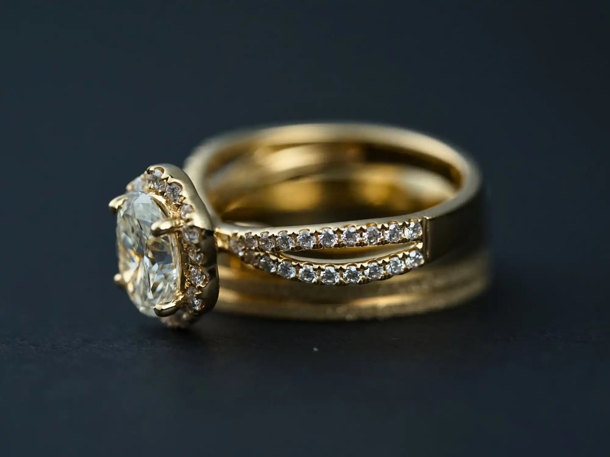 Gold engagement ring with a central oval diamond and smaller diamonds along split bands.