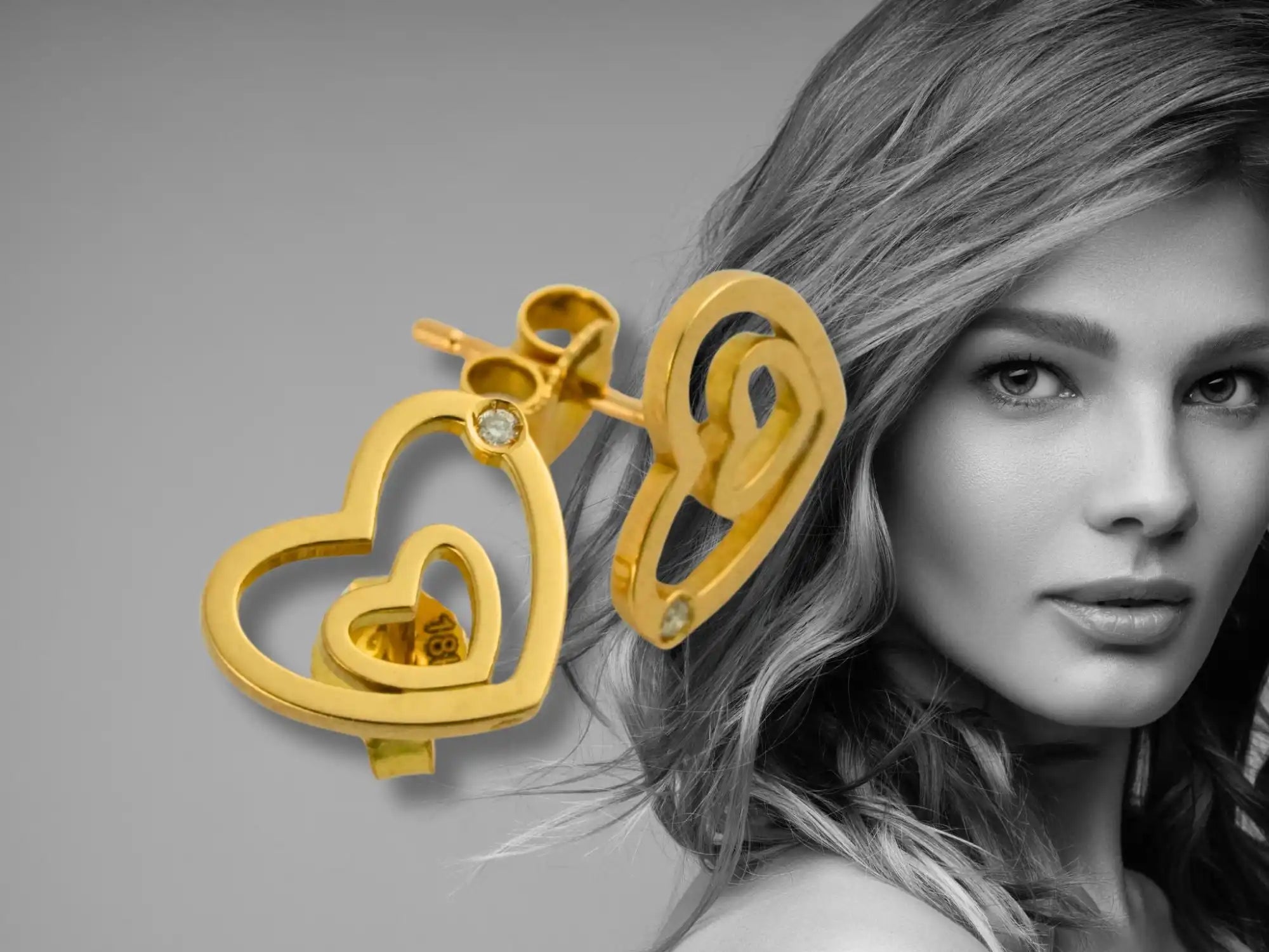 Gold heart-shaped earrings with a small heart cutout design.