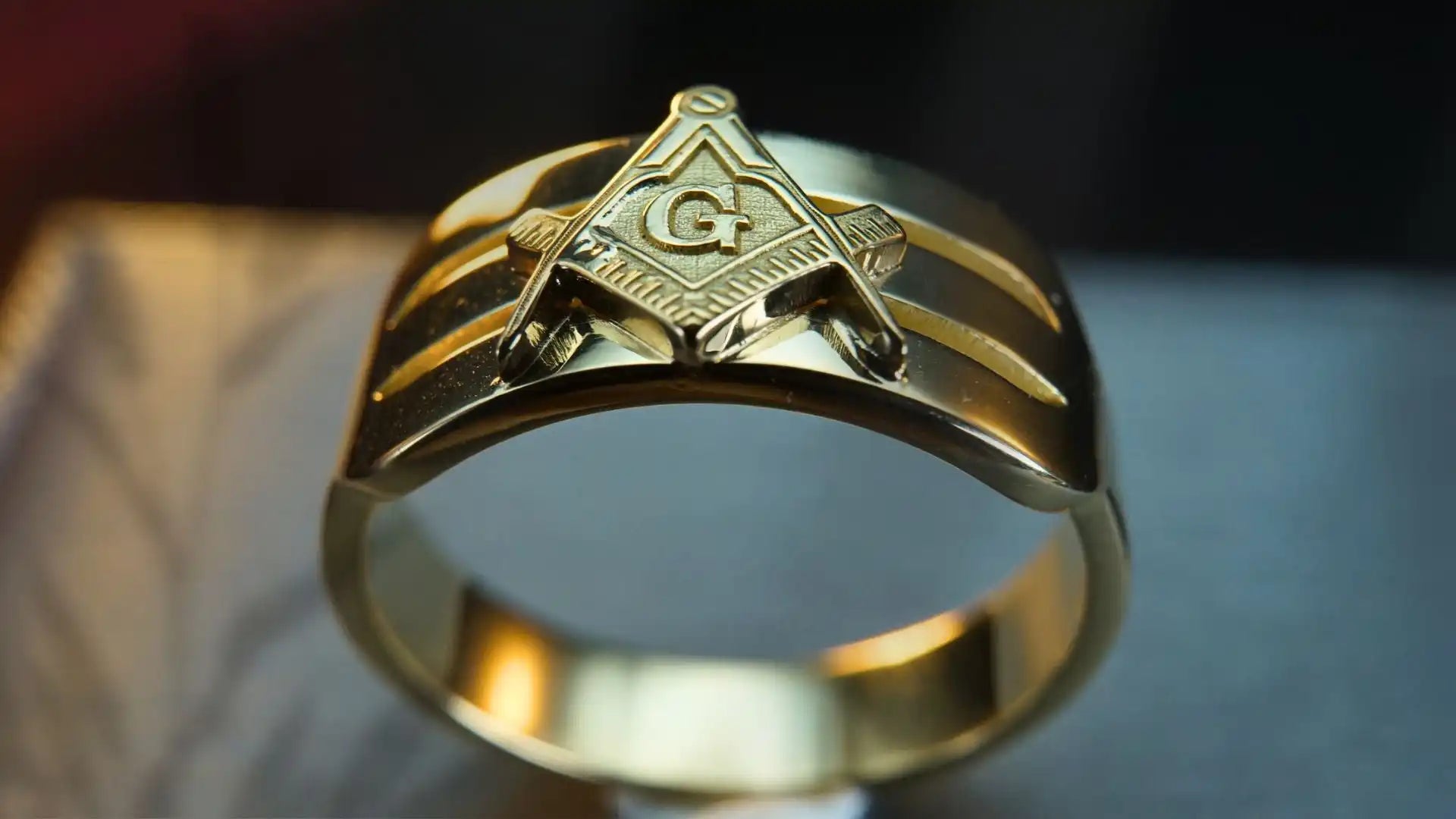 Gold Masonic ring featuring the square and compass symbol.