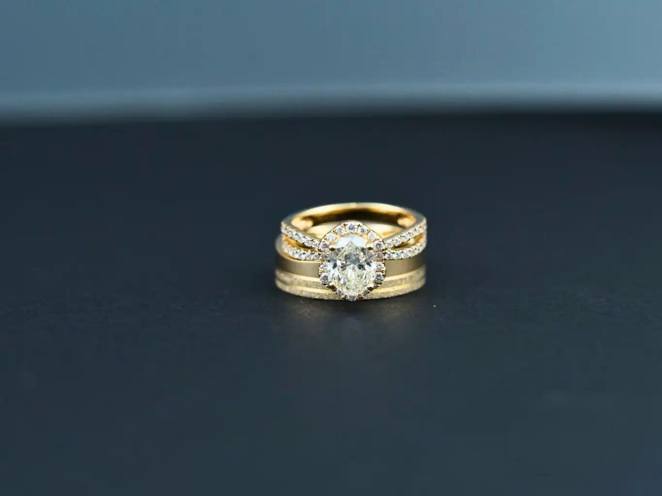 Gold wedding ring set featuring a round diamond center stone with accent diamonds on the band.