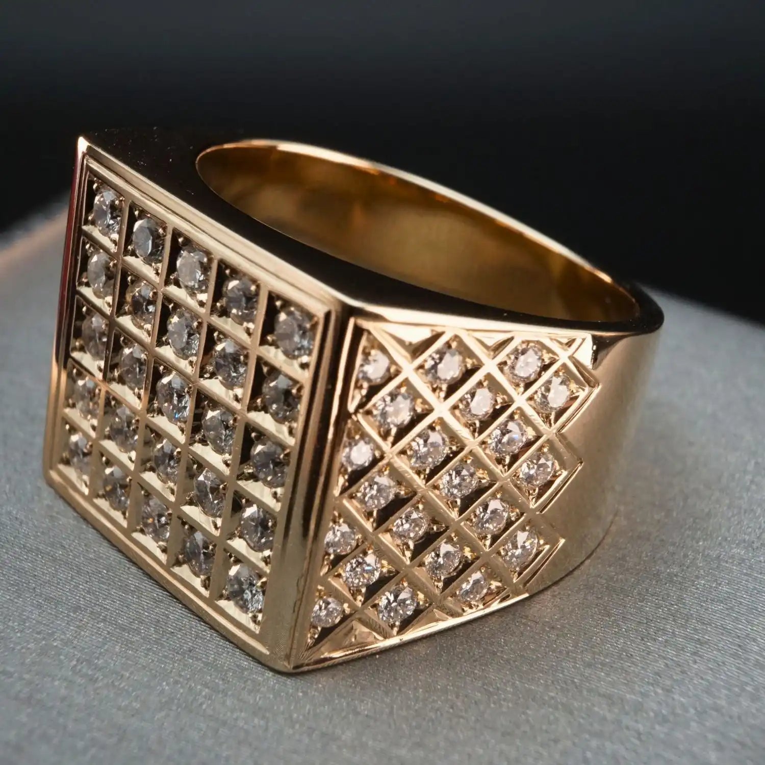 Gold ring with a square face featuring a grid pattern of inset diamonds.