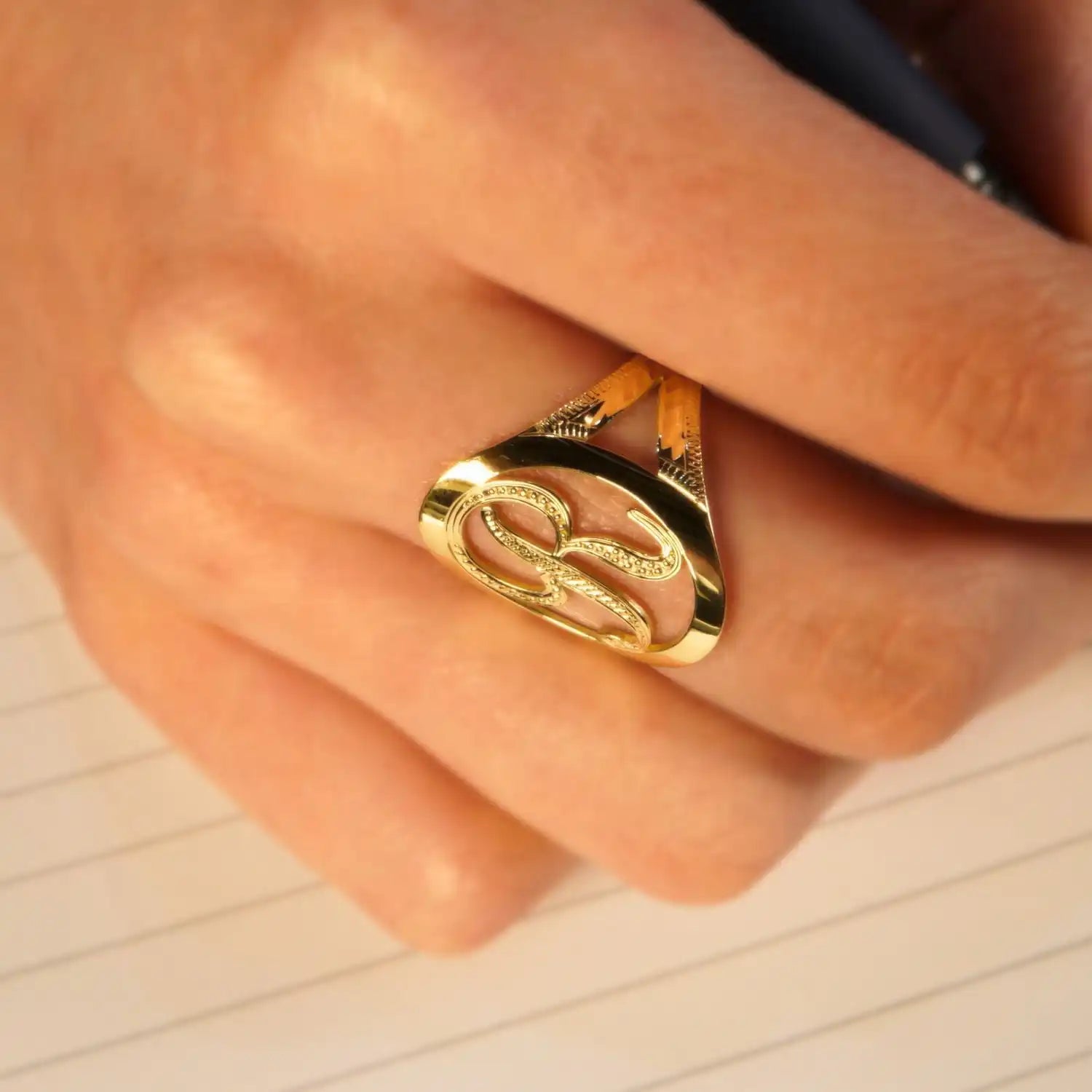 Gold-toned ring featuring an interlocking dollar sign design.