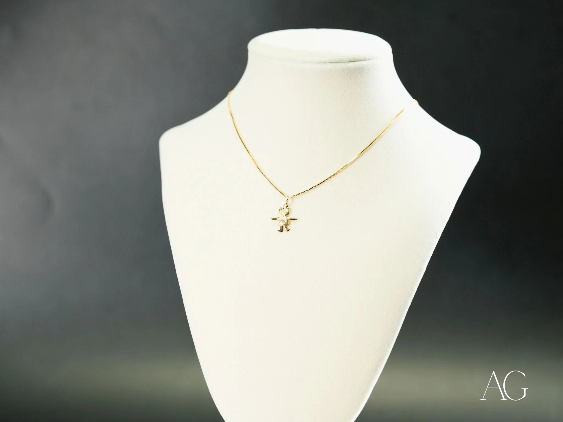 Gold necklace with a cross pendant on a white bust showcasing 18k gold charm