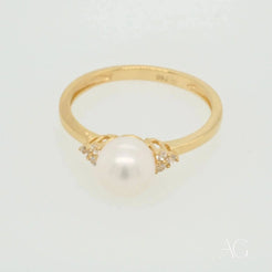 Stunning 7mm pearl ring in 18k gold with a central pearl and diamond accents