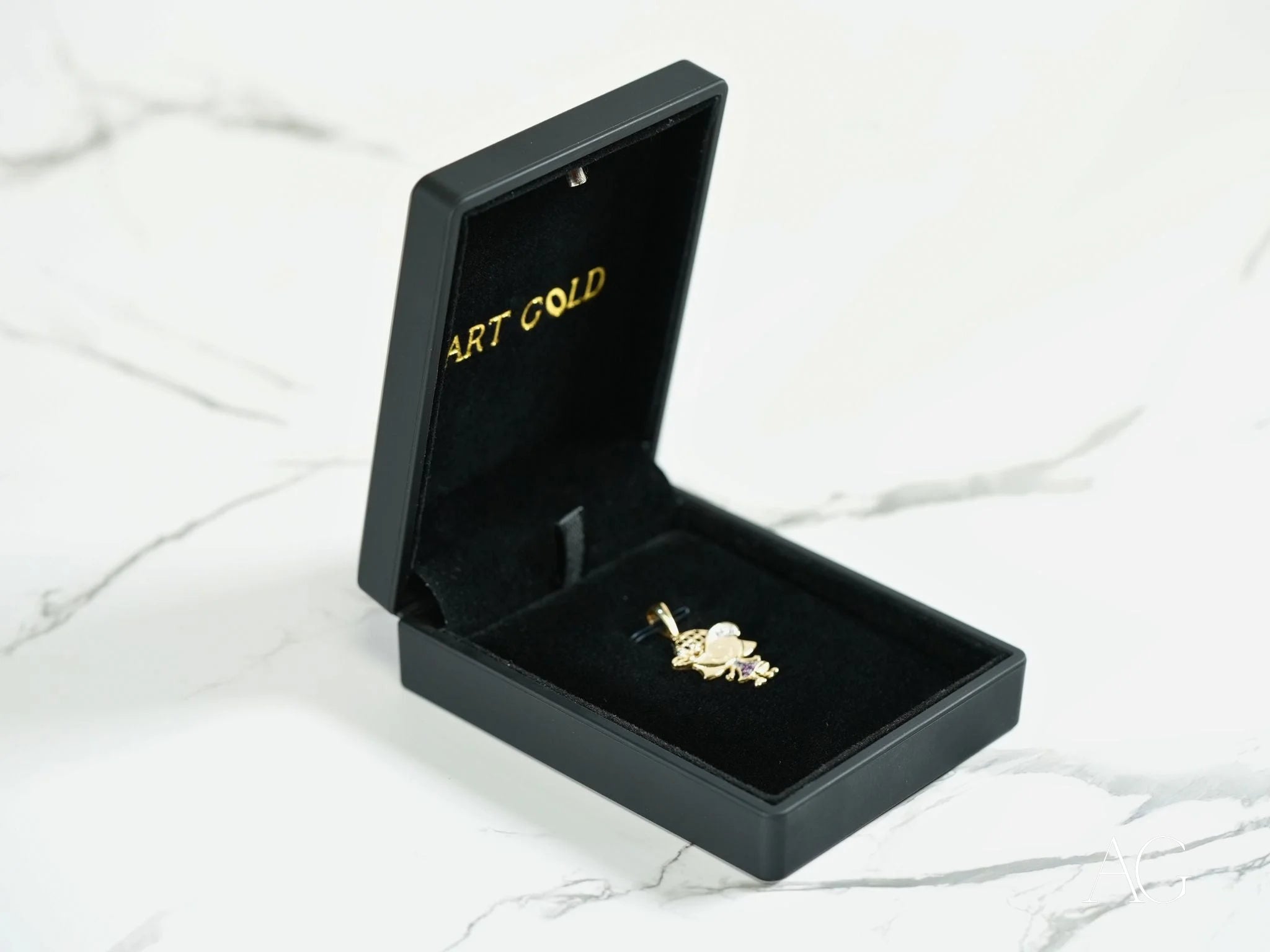 Gold ring with gemstone in black box featuring ART GOLD, Golden Son Pendant in 18k gold