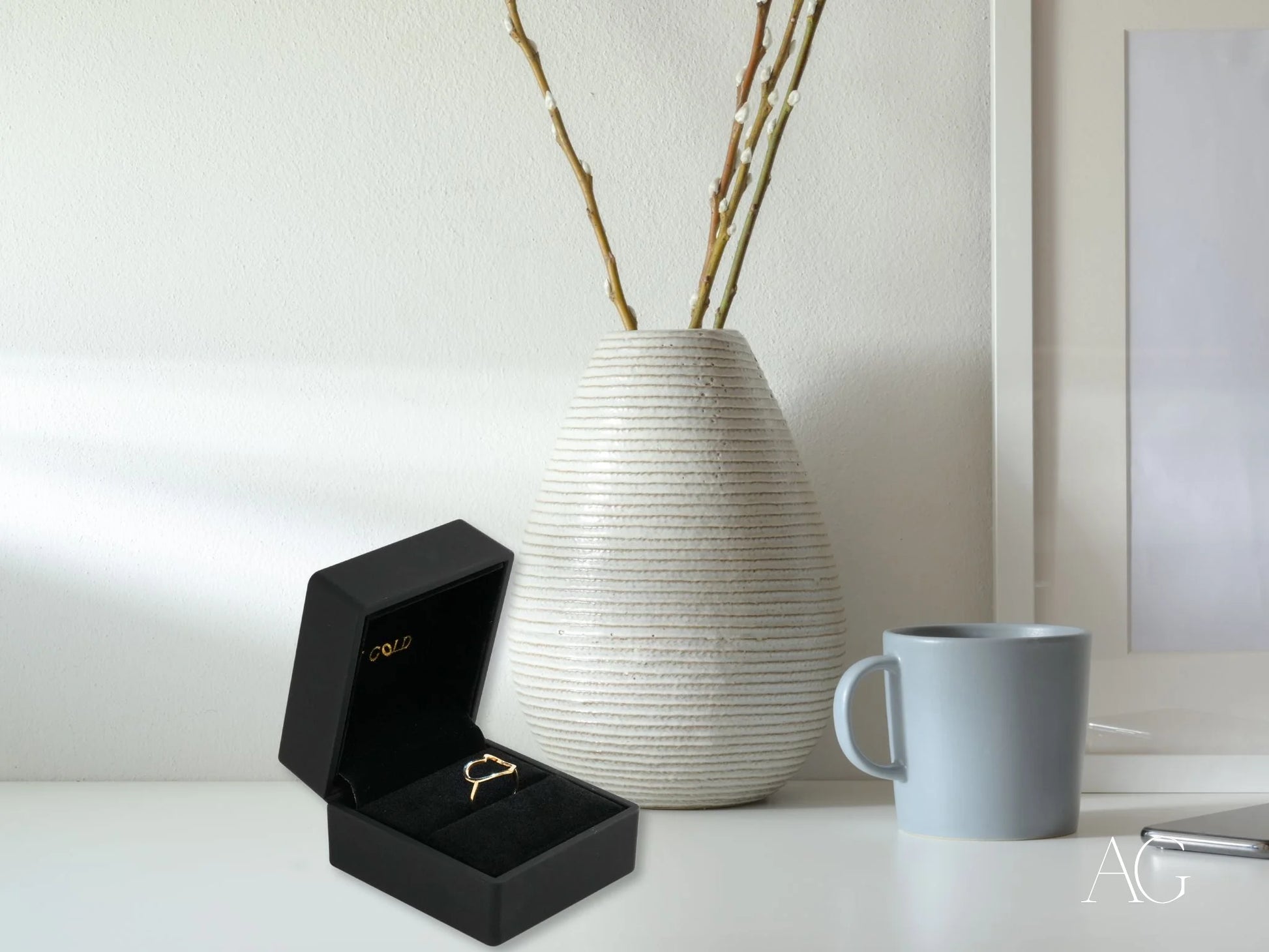 White ribbed ceramic vase with thin branches and Golden Heart Ring in 18k gold open-heart design