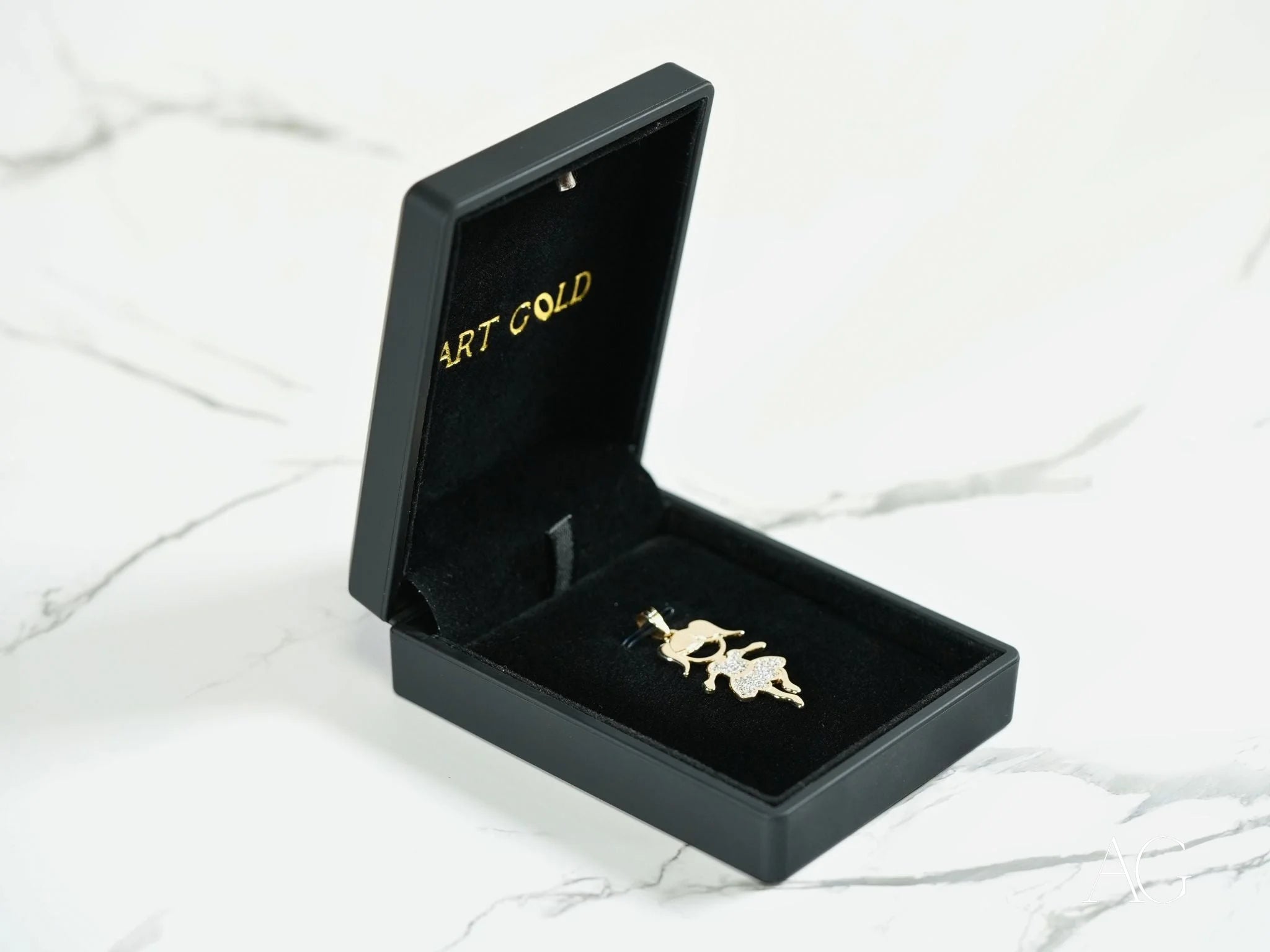 Gold-colored leaf-shaped pendant in a black box for Golden Moments 18k Gold jewelry