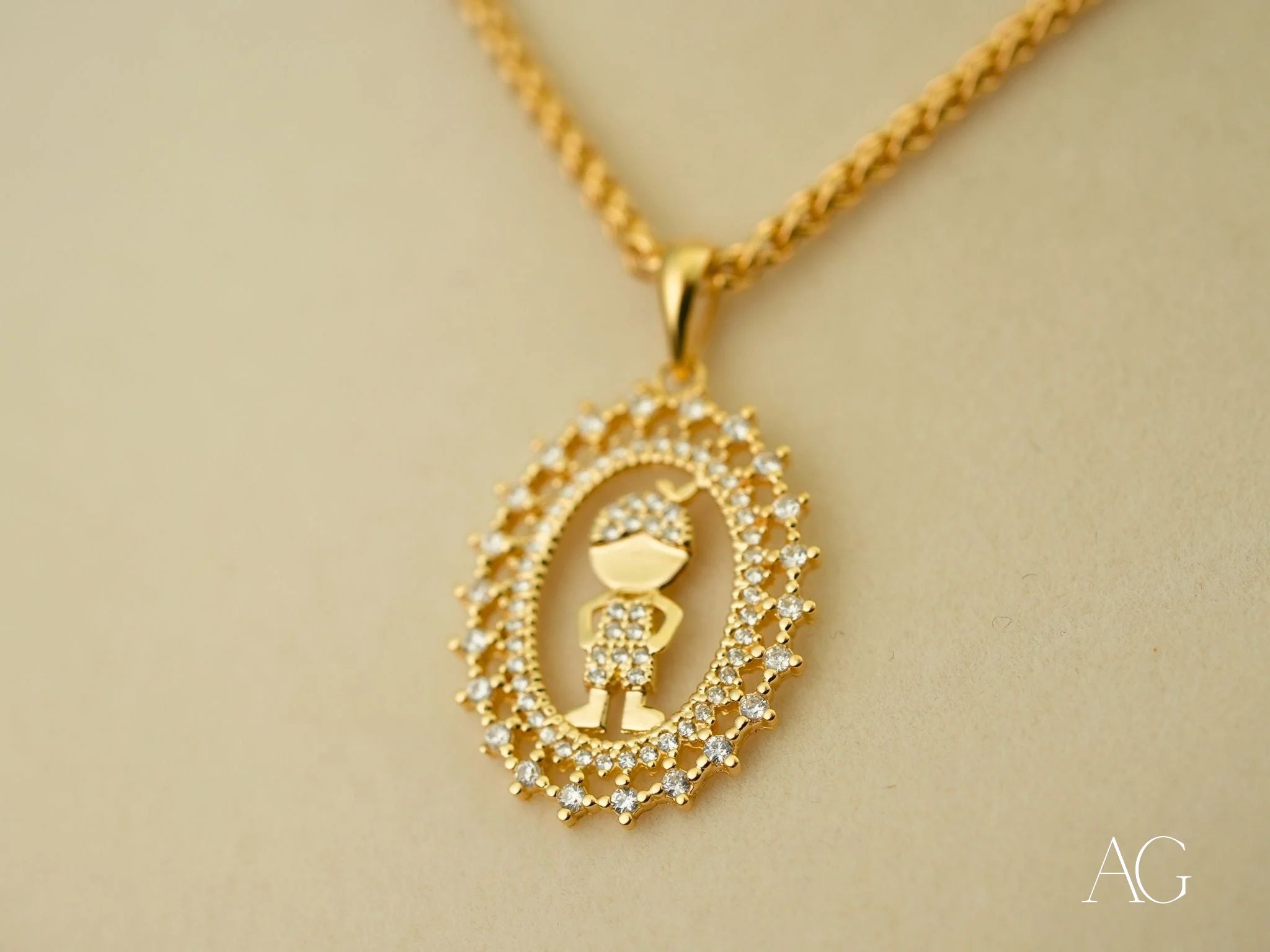 Gold pendant necklace featuring a boy design in 18k gold surrounded by crystals