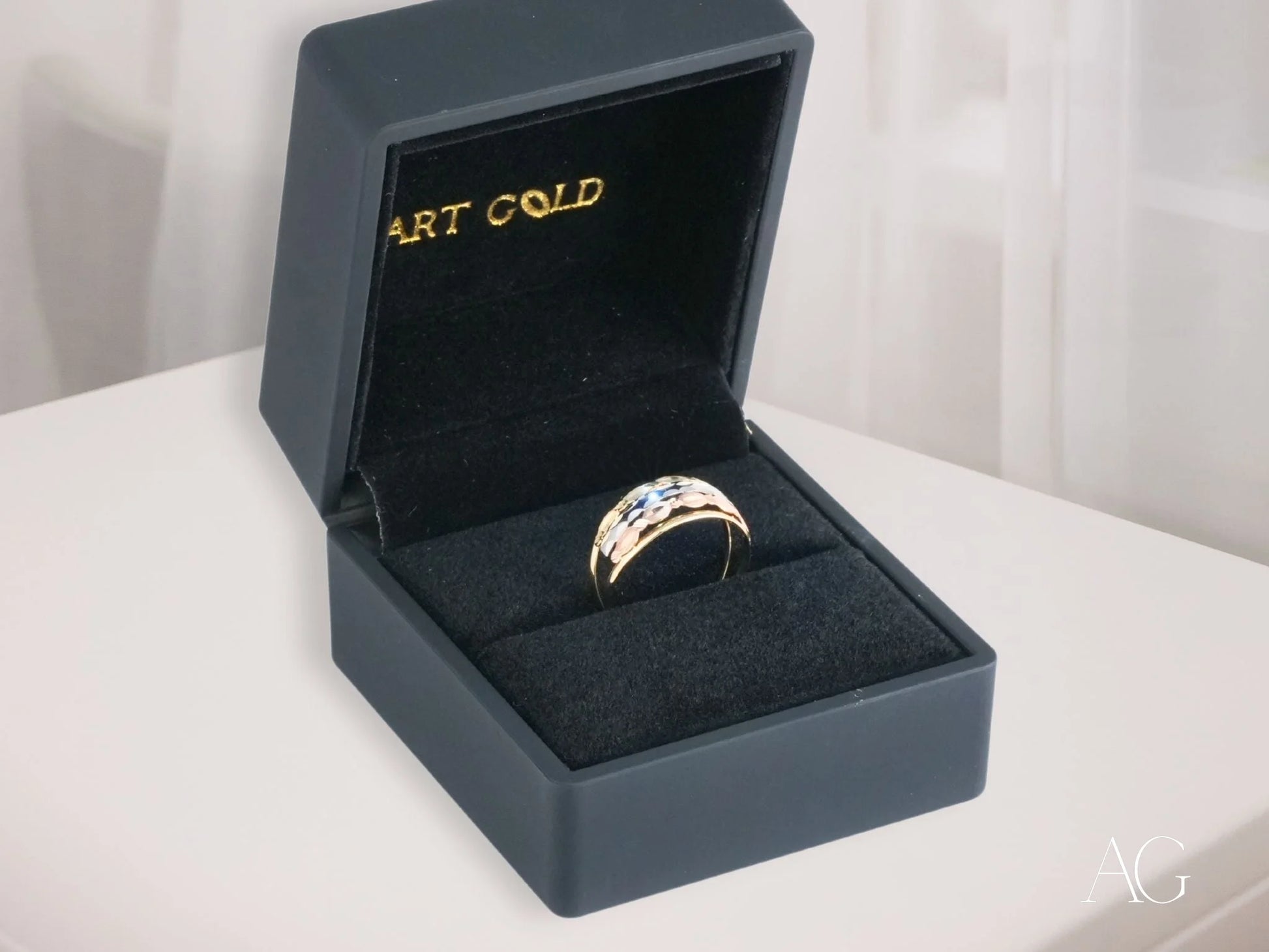 Gold ring with gemstones in a black box showcasing Golden Spectrum 18k Gold design