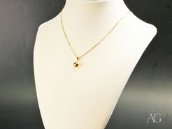 Gold-toned 18k gold necklace featuring a golden sphere bead pendant on a delicate chain