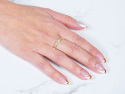 Hand showcasing the Golden Grace 18k Aparador Ring and elegant French manicure nails