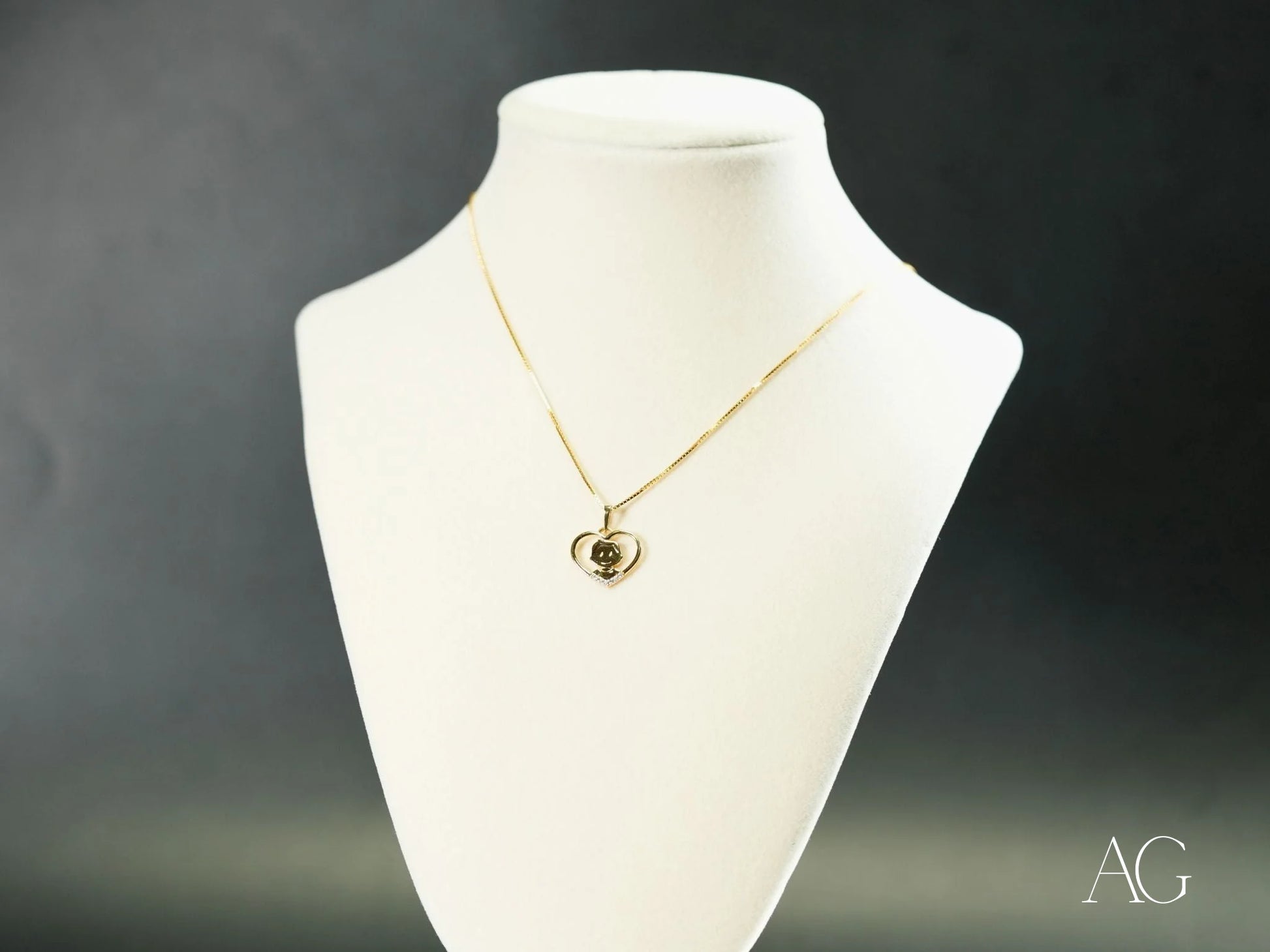 Gold necklace featuring a circular 18k Gold pendant on a white jewelry bust