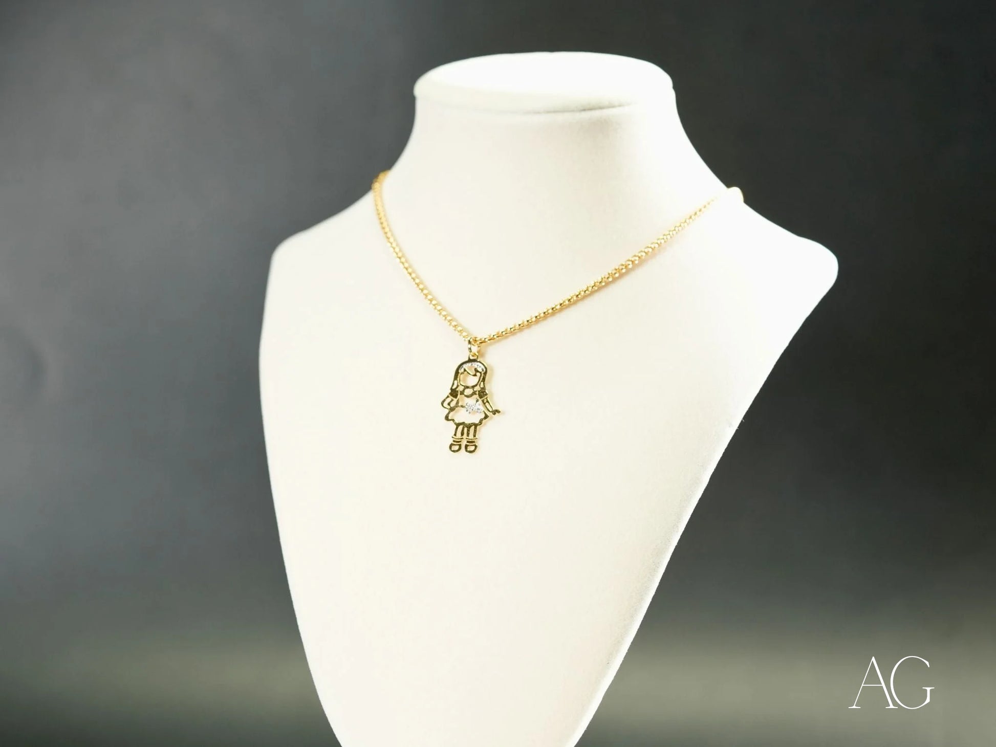 Gold-colored 18k gold necklace featuring a girl-shaped charm pendant from Golden Treasures