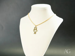 Gold-colored 18k gold necklace featuring a girl-shaped charm pendant from Golden Treasures