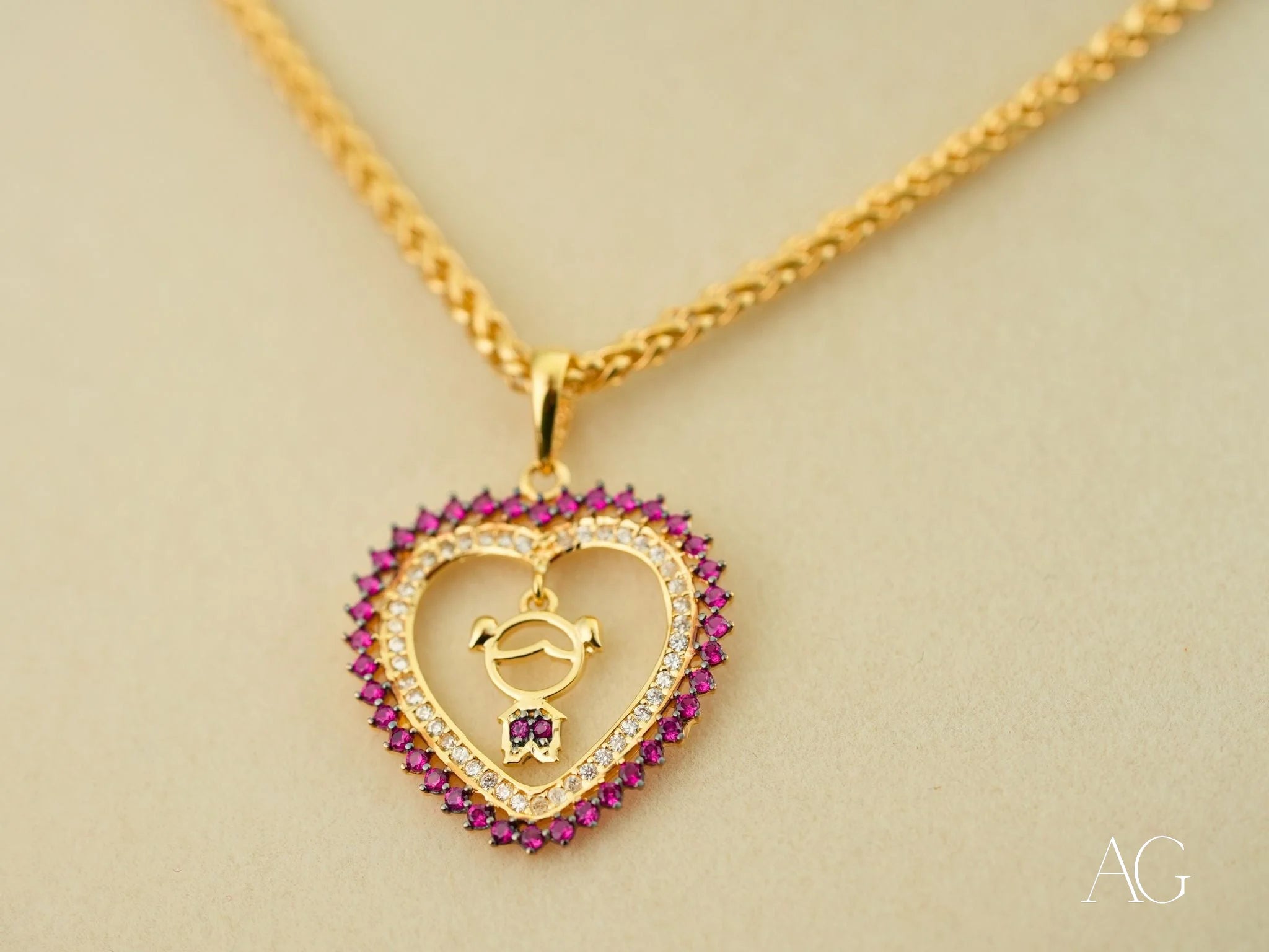 Gold heart-shaped pendant with pink gemstones and bee design from Golden Passion collection