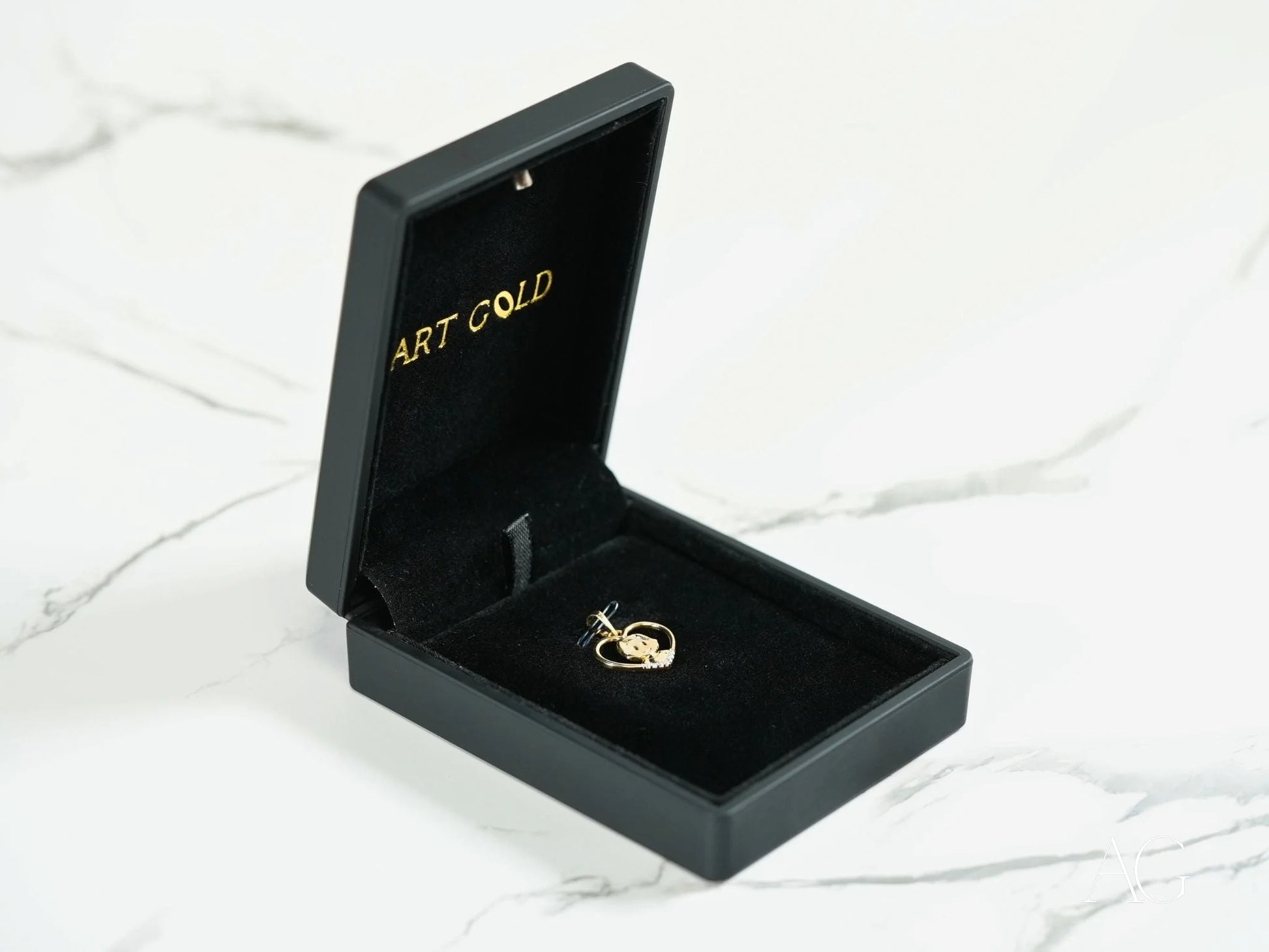 Black jewelry box featuring a Golden Love 18k Gold heart-shaped pendant