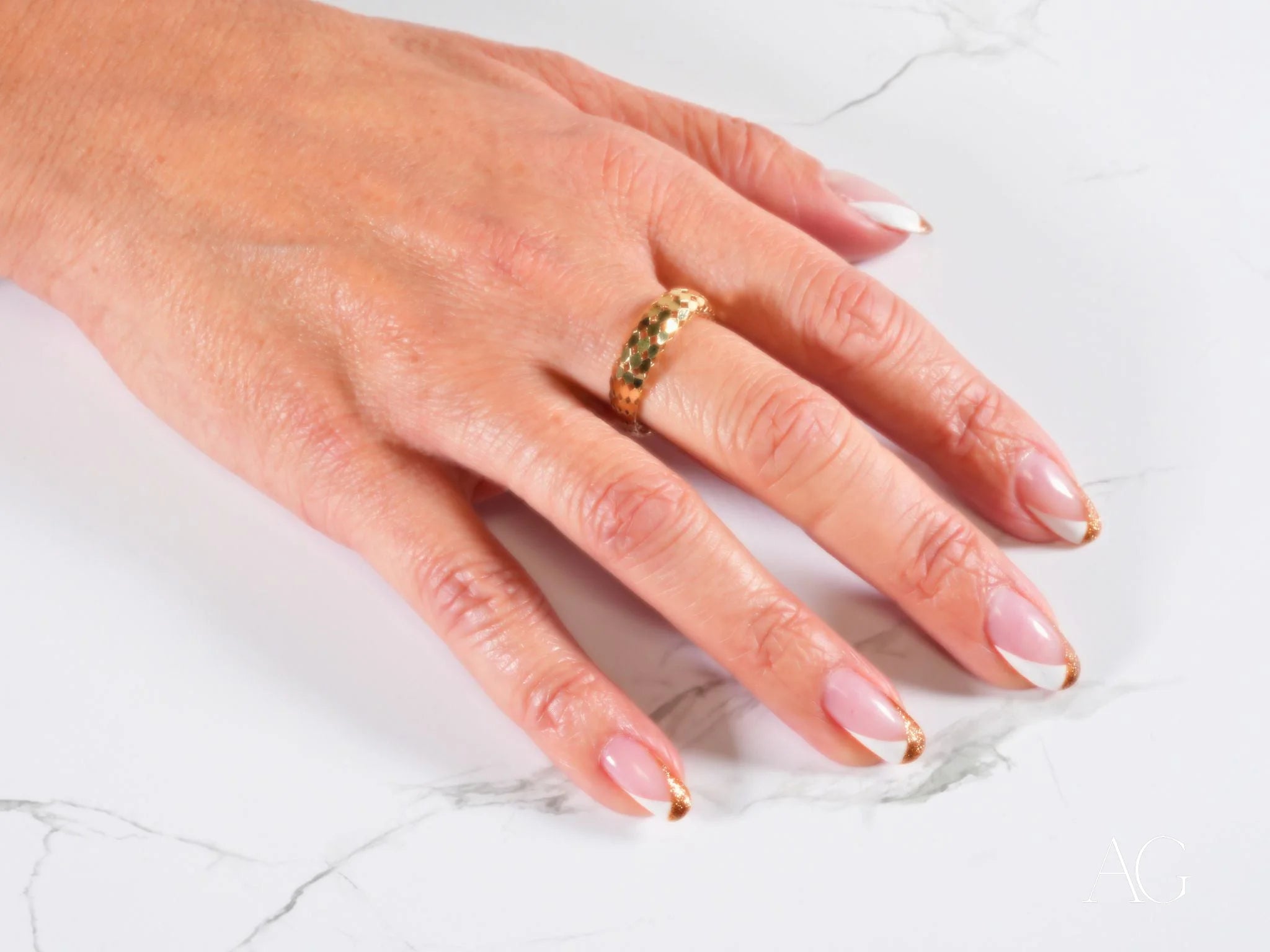 Hand adorned with 18k gold Golden Mesh Elegance Ring and French manicured nails