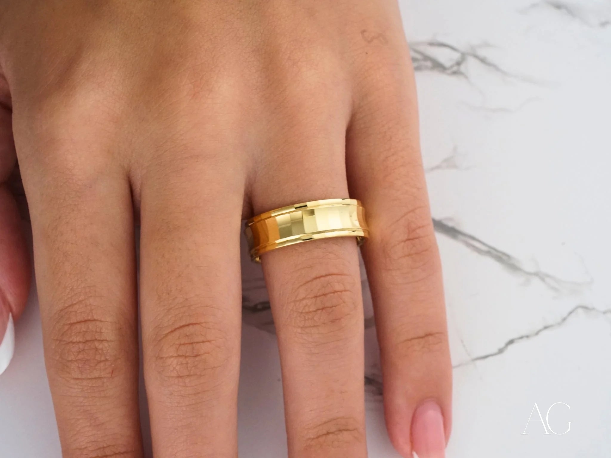 Gold wedding band on a finger showcasing the Golden Cascade design in 14k gold