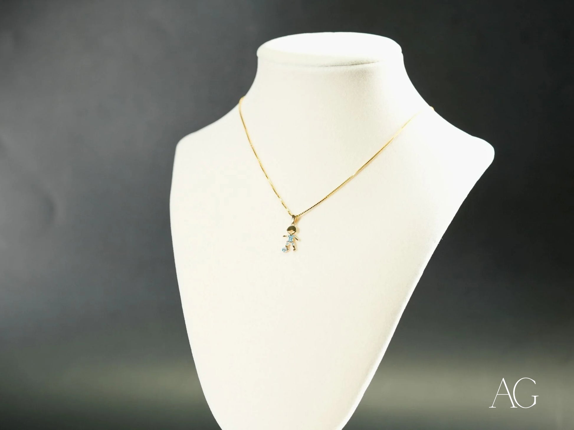 Gold necklace with Golden Charm CZ Doll Pendant in 18k yellow gold on a jewelry bust