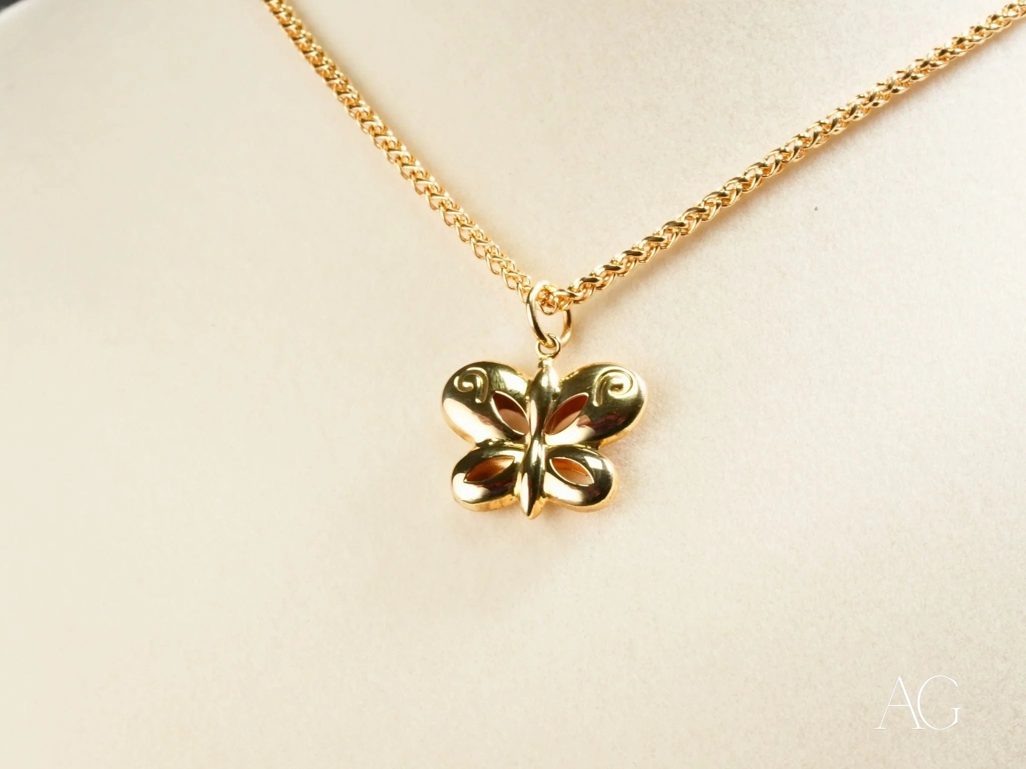 Gold butterfly pendant on a delicate chain necklace symbolizes personal growth in 18k gold