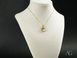 18k Gold heart pendant necklace on a white jewelry bust showcasing golden heart design