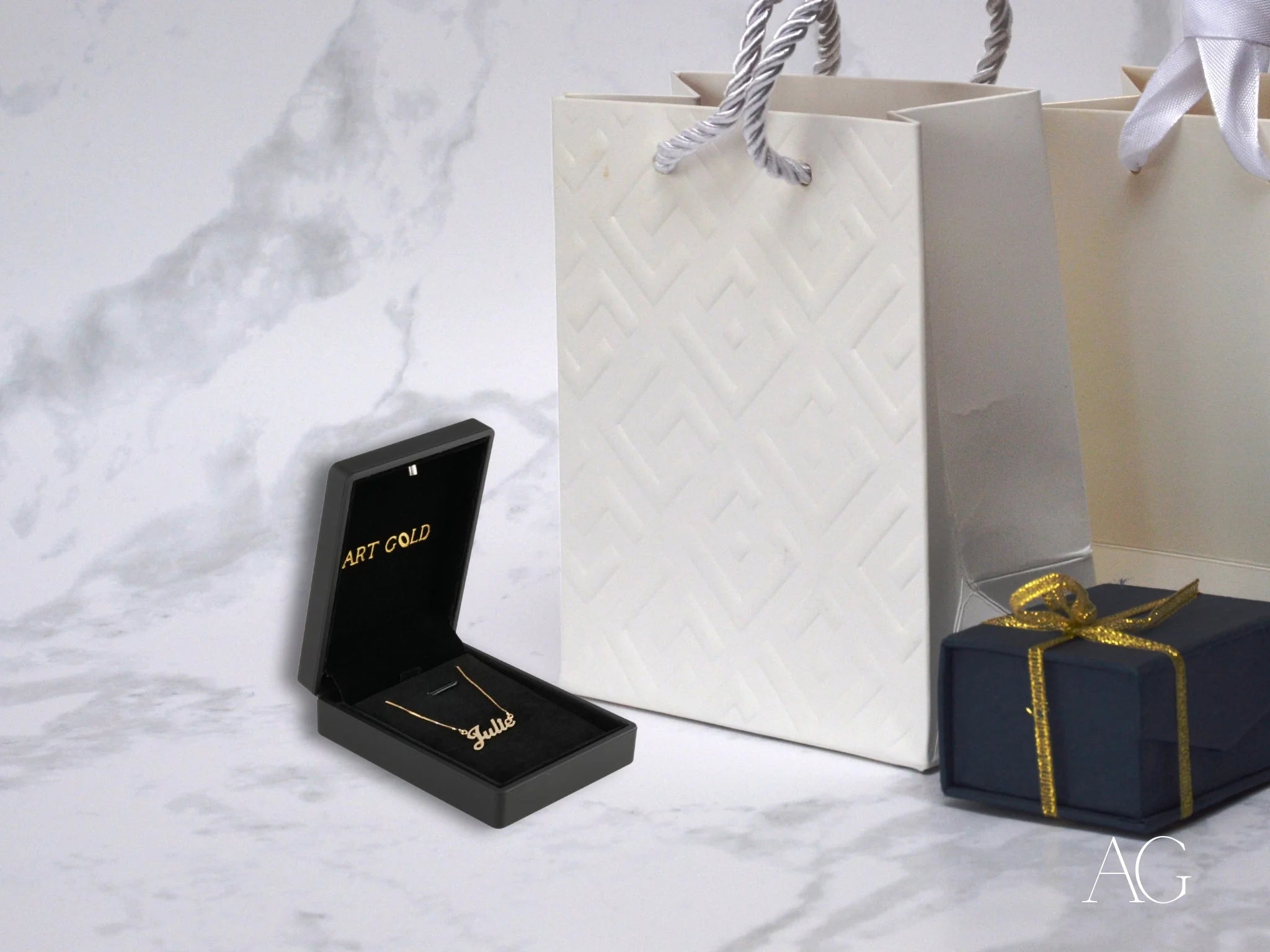 Black jewelry box with 18k gold custom name necklace and spring ring lock beside gifts