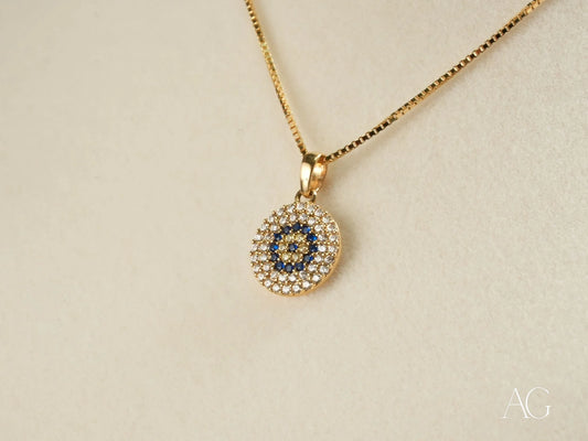 Gold pendant necklace with circular evil eye design and cubic zirconia in Golden Spark
