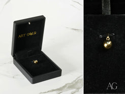 Gold spherical pendant in a black jewelry box, showcasing an elegant 18k gold design